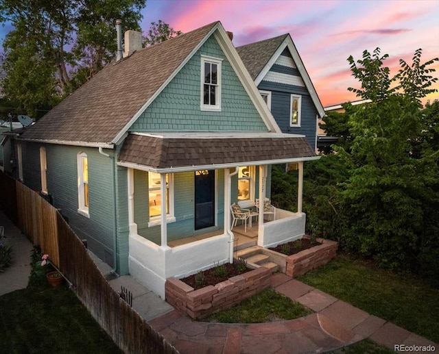 2527 W Dunkeld Pl, Denver, CO 80211 - view of front of house featuring covered porch, roof with shingles, a chimney, and brick siding