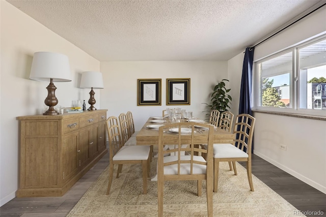 dining space with hardwood / wood-style flooring and a textured ceiling