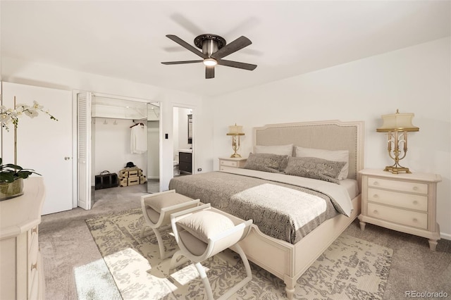 bedroom featuring light colored carpet, ensuite bath, and ceiling fan