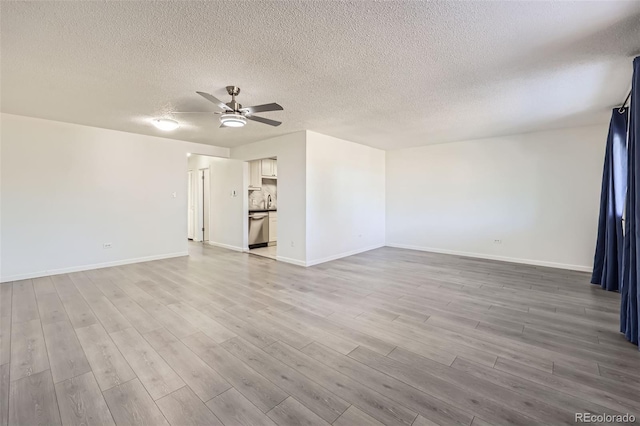 empty room with ceiling fan, a textured ceiling, and light hardwood / wood-style flooring