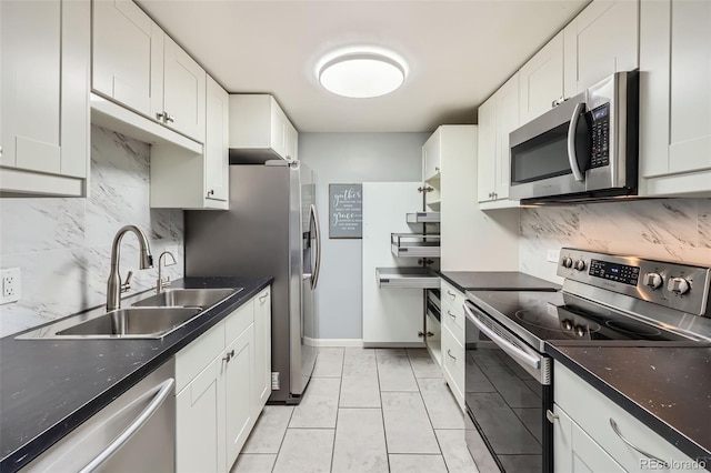 4940 E Donald Ave Unit 8, Denver, CO 80222 - kitchen with appliances with stainless steel finishes, decorative backsplash, white cabinetry, and dark stone countertops