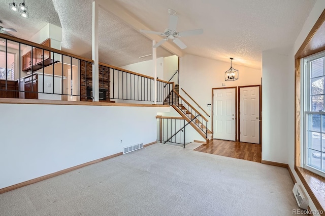 interior space featuring ceiling fan with notable chandelier, a healthy amount of sunlight, and lofted ceiling