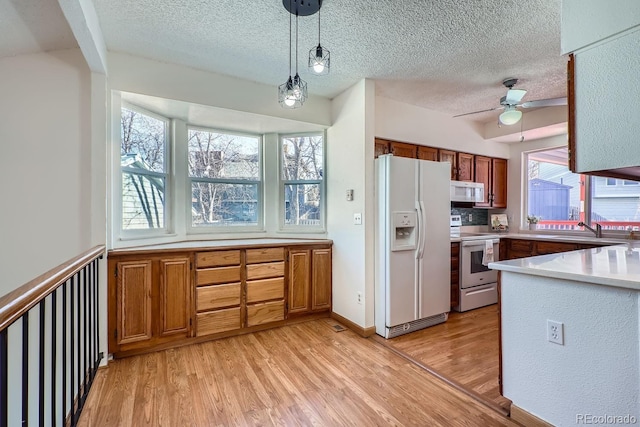 kitchen with white appliances, decorative light fixtures, decorative backsplash, ceiling fan, and sink