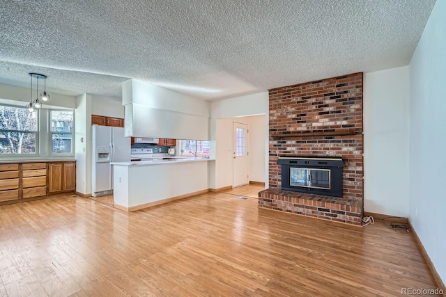 unfurnished living room featuring a brick fireplace, light wood-type flooring, and a wealth of natural light