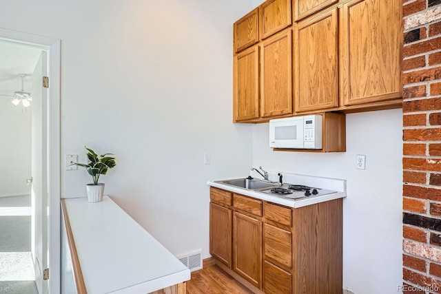 kitchen featuring light wood-type flooring, ceiling fan, and sink