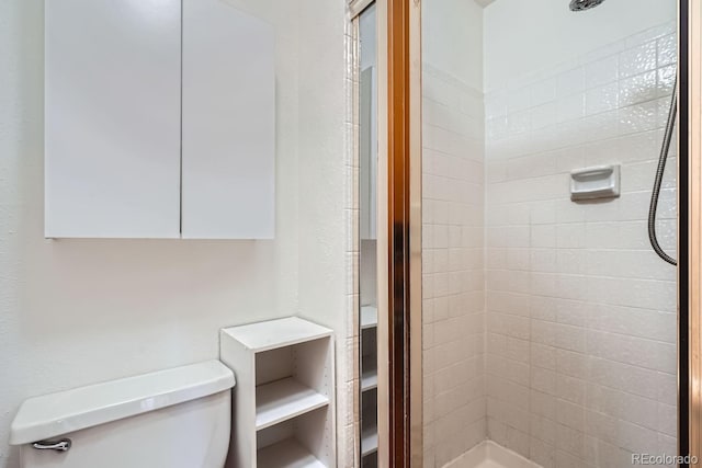 bathroom featuring toilet and tiled shower