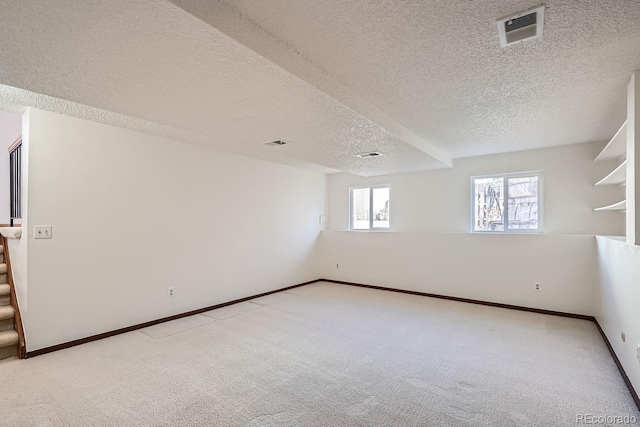 carpeted spare room with a textured ceiling