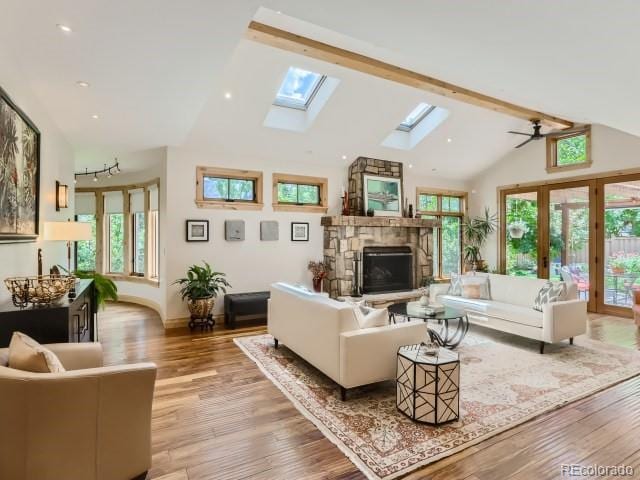 3135 11th St, Boulder, CO 80304 - living area with high vaulted ceiling, a fireplace, a skylight, wood finished floors, and a ceiling fan
