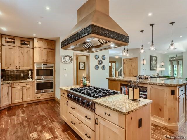 3135 11th St, Boulder, CO 80304 - kitchen with island range hood, light brown cabinets, stainless steel appliances, a kitchen island, and wood finished floors