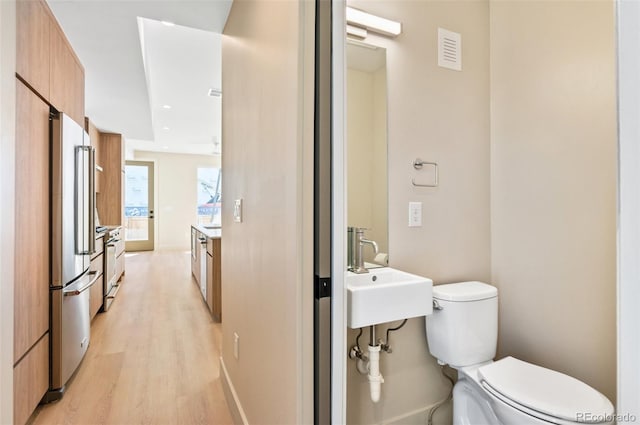 bathroom with sink, hardwood / wood-style flooring, and toilet