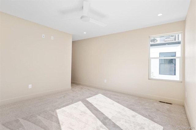 carpeted spare room featuring ceiling fan