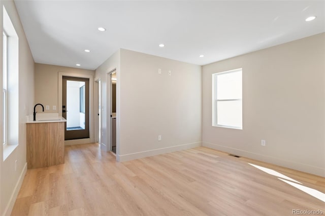 spare room featuring light wood-type flooring and sink