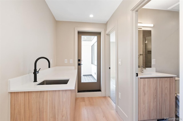 entryway with sink and light wood-type flooring