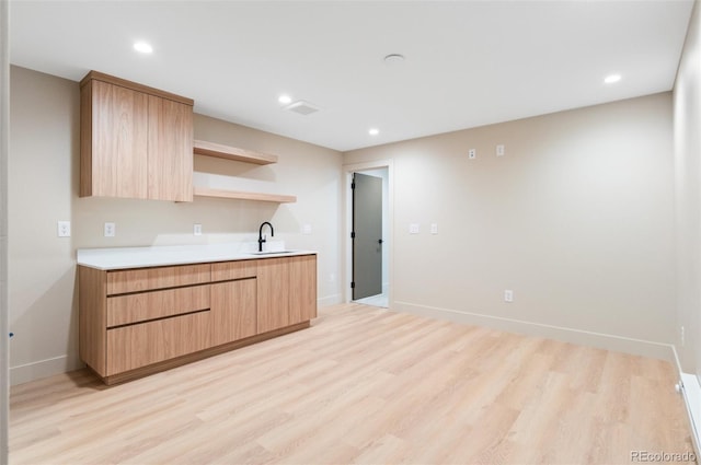 kitchen featuring sink, light brown cabinets, and light wood-type flooring