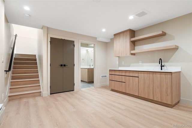 kitchen featuring light brown cabinetry, sink, and light wood-type flooring