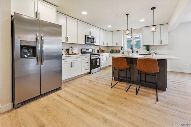 3533 Saguaro Cir, Colorado Springs, CO 80925 - kitchen with stainless steel appliances, light countertops, white cabinetry, light wood-style floors, and recessed lighting