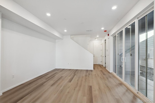 spare room featuring light wood-style flooring, visible vents, baseboards, and recessed lighting