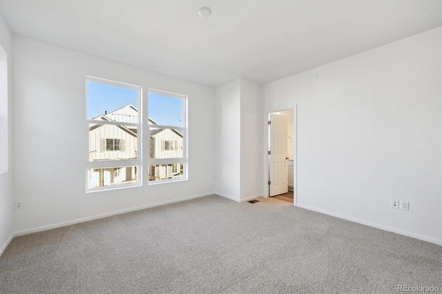 spare room featuring light colored carpet