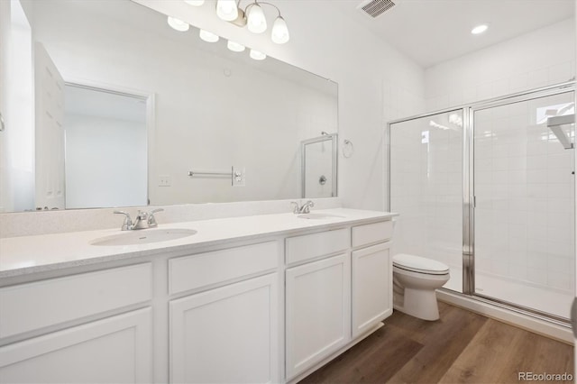 bathroom with vanity, hardwood / wood-style flooring, toilet, and walk in shower