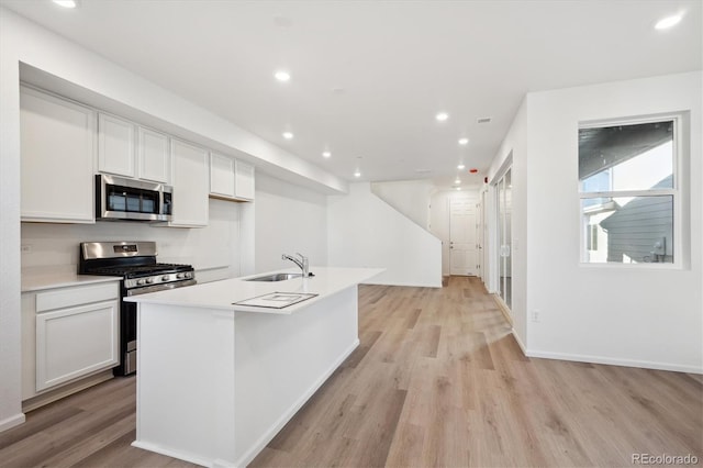 kitchen with light wood-style floors, stainless steel appliances, a sink, and recessed lighting