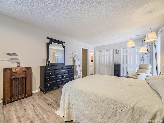 bedroom with light wood-type flooring and a textured ceiling