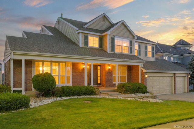 view of front of property with a yard, a garage, and a porch