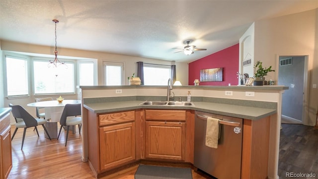 kitchen featuring dishwasher, a sink, lofted ceiling, light wood finished floors, and a ceiling fan