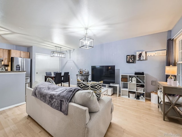 living room with light hardwood / wood-style floors and an inviting chandelier