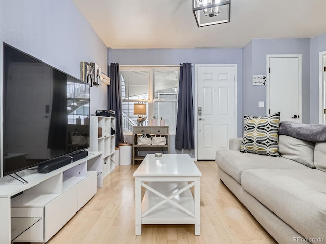 living room featuring a notable chandelier and light hardwood / wood-style floors