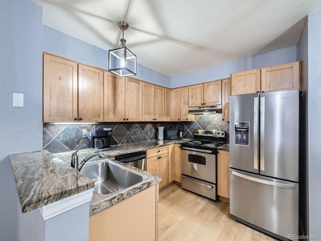 kitchen featuring pendant lighting, sink, tasteful backsplash, kitchen peninsula, and stainless steel appliances