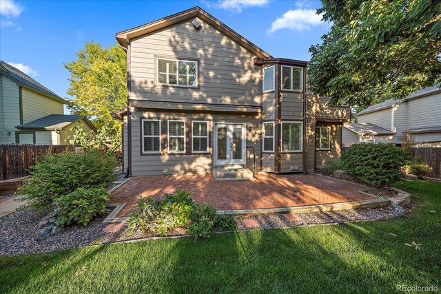 back of house with a lawn and a patio