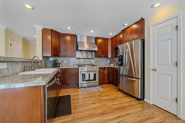 kitchen with ornamental molding, appliances with stainless steel finishes, sink, and wall chimney exhaust hood