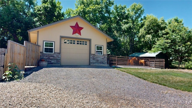 view of front of property with a garage and an outbuilding