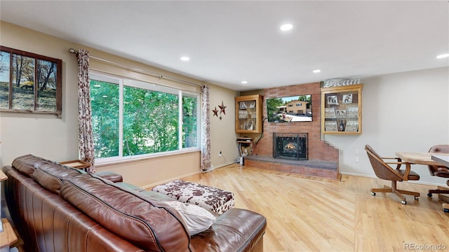 living room featuring a brick fireplace and hardwood / wood-style flooring