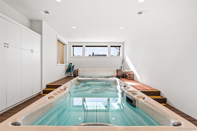 view of swimming pool featuring an indoor hot tub