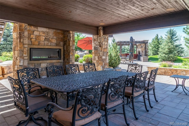 view of patio featuring an outdoor stone fireplace and outdoor dining space