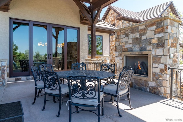 view of patio / terrace featuring an outdoor stone fireplace and outdoor dining area