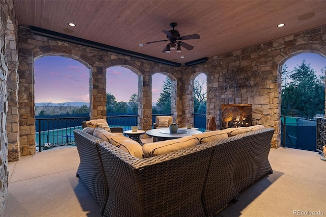 view of patio / terrace with an outdoor living space with a fireplace and ceiling fan