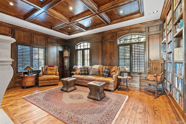 living area with wooden ceiling, crown molding, light wood-style flooring, coffered ceiling, and french doors