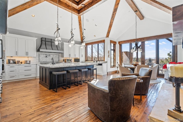 living area featuring beamed ceiling, high vaulted ceiling, and light wood finished floors