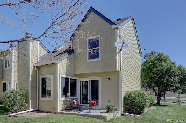 10359 W Fair Ave Unit F, Littleton, CO 80127 - back of property with a patio, a chimney, a yard, and a shingled roof