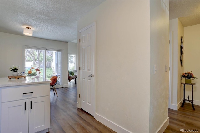 10359 W Fair Ave Unit F, Littleton, CO 80127 - hallway with a textured ceiling, wood finished floors, and baseboards