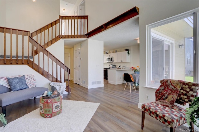 10359 W Fair Ave Unit F, Littleton, CO 80127 - living room featuring light wood-style floors, stairs, and baseboards