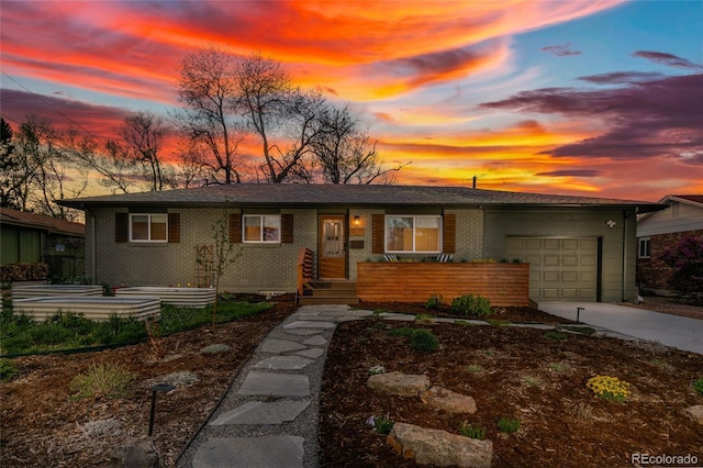 4655 Ludlow St, Boulder, CO 80305 - view of front of house featuring concrete driveway, an attached garage, and brick siding