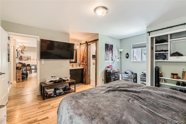 6213 Willow Ln, Boulder, CO 80301 - bedroom featuring light wood-style floors, a barn door, and ensuite bathroom