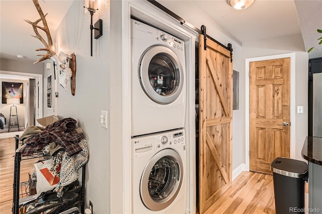 6213 Willow Ln, Boulder, CO 80301 - laundry area with stacked washer / drying machine, light wood-style floors, a barn door, and electric panel