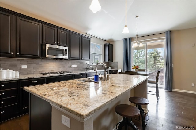 2724 Rising Moon Way, Castle Rock, CO 80109 - kitchen with stainless steel appliances, a sink, backsplash, baseboards, and light stone counters
