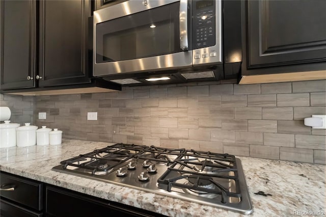 2724 Rising Moon Way, Castle Rock, CO 80109 - kitchen featuring stainless steel appliances, backsplash, and light stone countertops