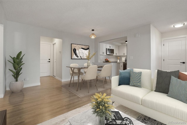 living room with light wood-type flooring and a textured ceiling