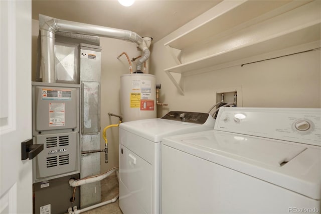 clothes washing area with washing machine and dryer and gas water heater